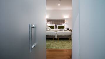 A hotel room with a bed, bedside tables, and a green carpet.