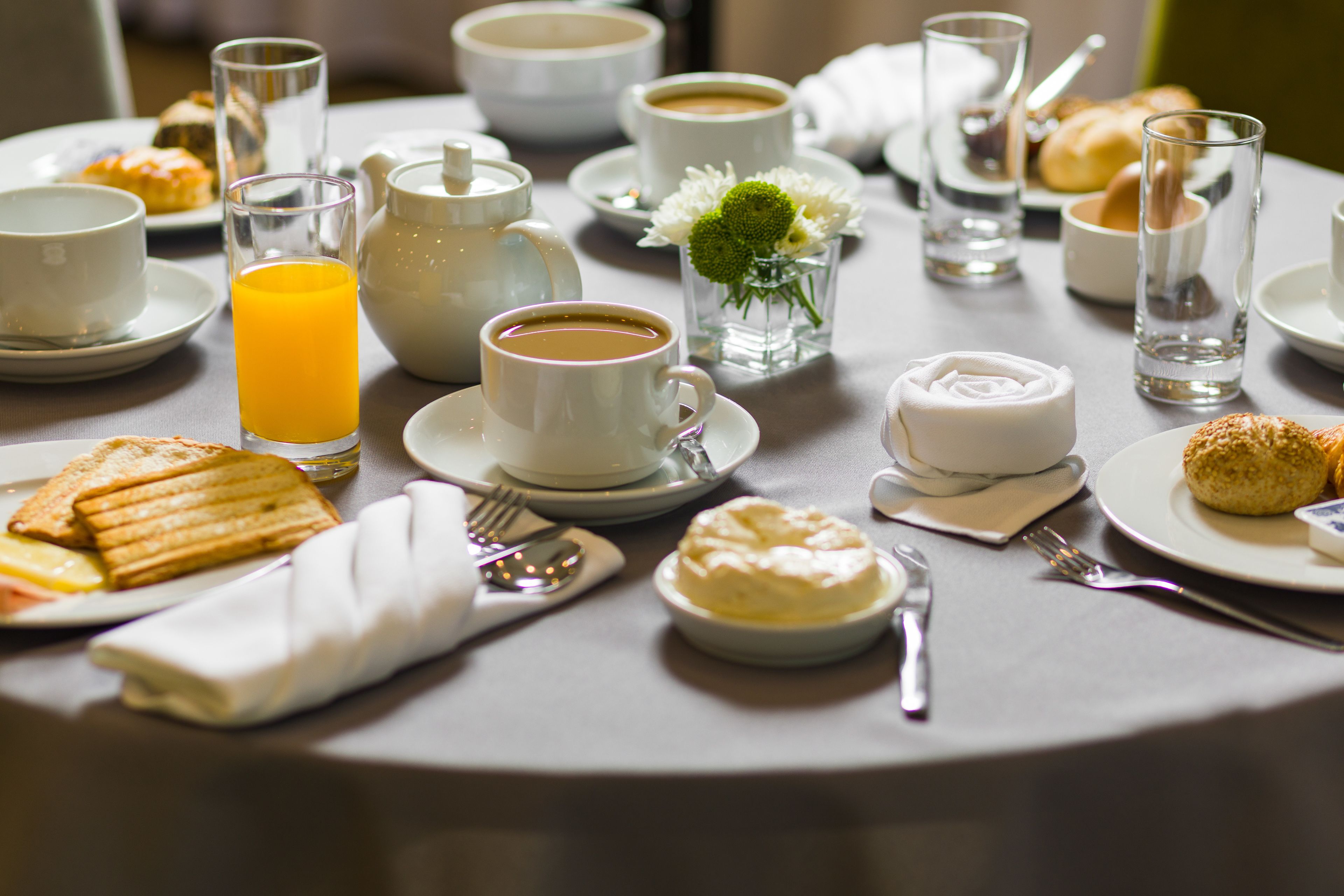 A breakfast setting with various dishes, including toast, pastries, and a coffee cup.