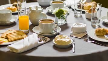 A breakfast setting with various dishes, including toast, pastries, and a coffee cup.