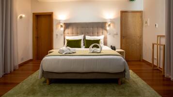 A neatly made bed with a green throw, a wooden headboard, and two bedside lamps.