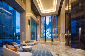 A modern lobby with a seating area, large windows, and a digital forest display. - Radisson Ningbo Beilun (Ningbo)