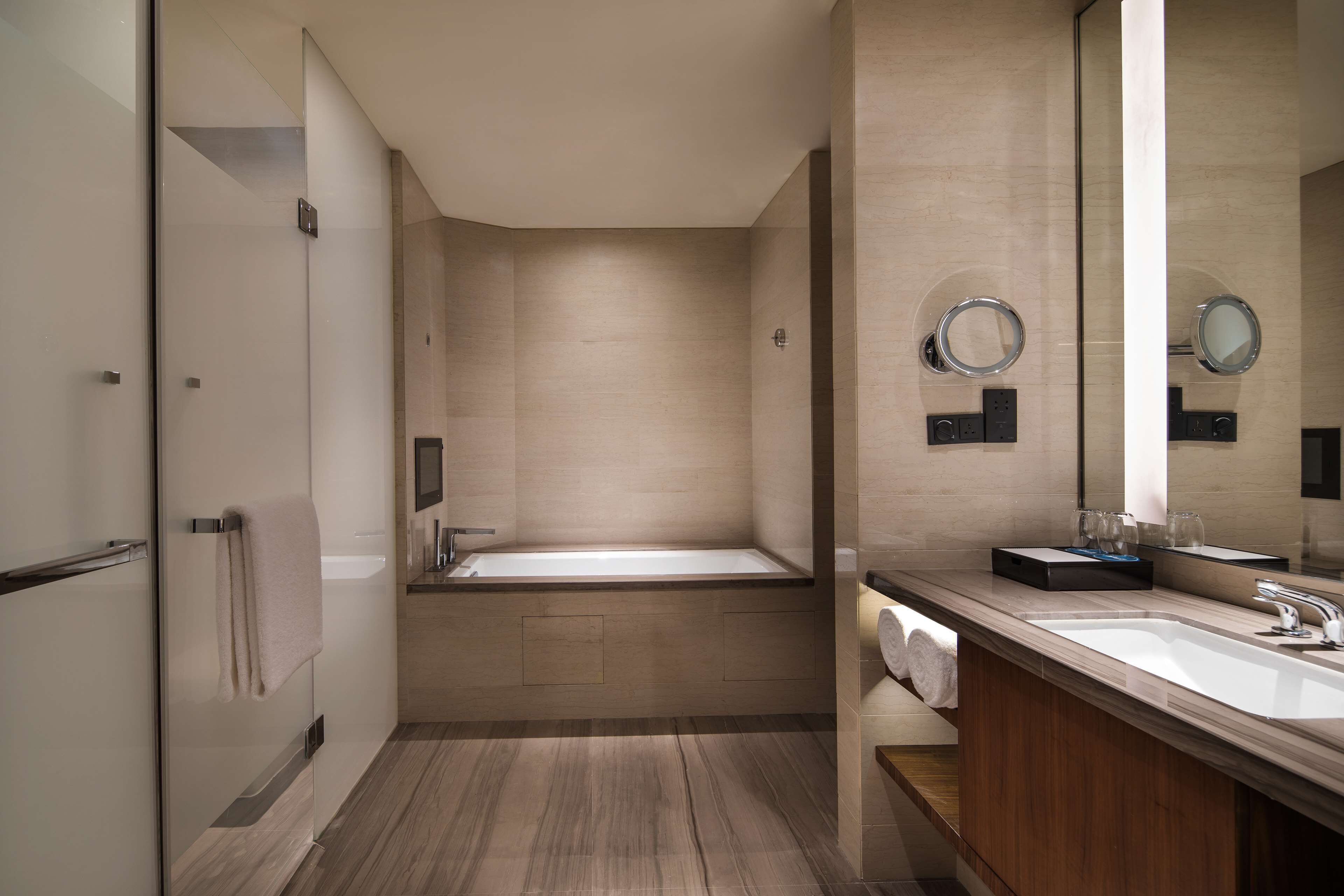 Un baño moderno con una bañera, un lavabo y un espejo grande.