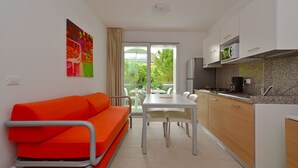 Een moderne keuken met een eettafel en een feloranje bank.