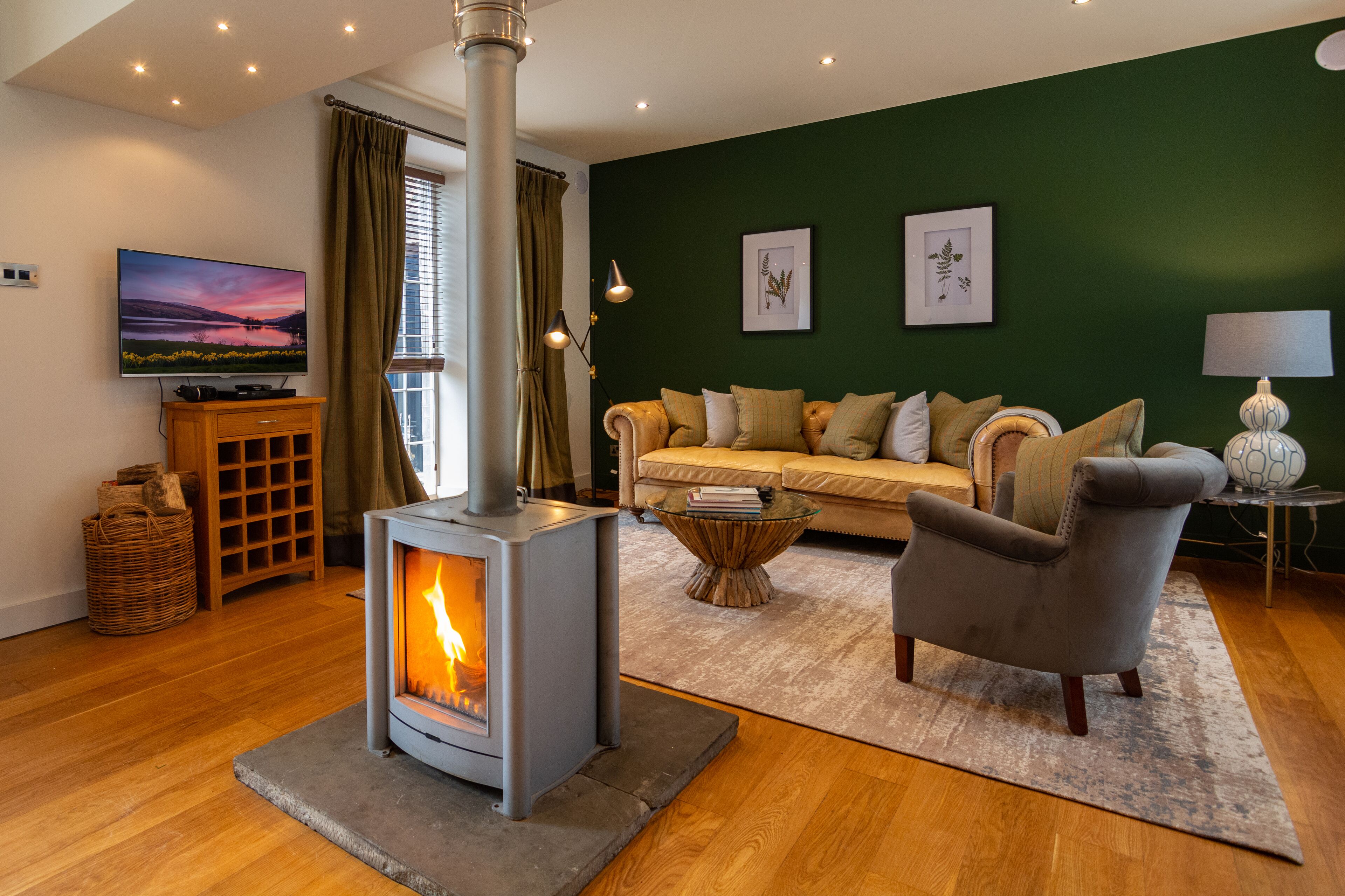 A cozy living room with a wood-burning stove, a sofa, and a television.