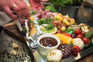 A charcuterie board with various meats, vegetables, and condiments. - Hotel-restauracja Platan (Chrzanow)