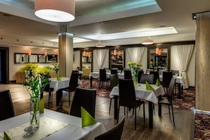A hotel dining area with multiple tables, chairs, and a bar area. - Hotel-restauracja Platan (Chrzanow)