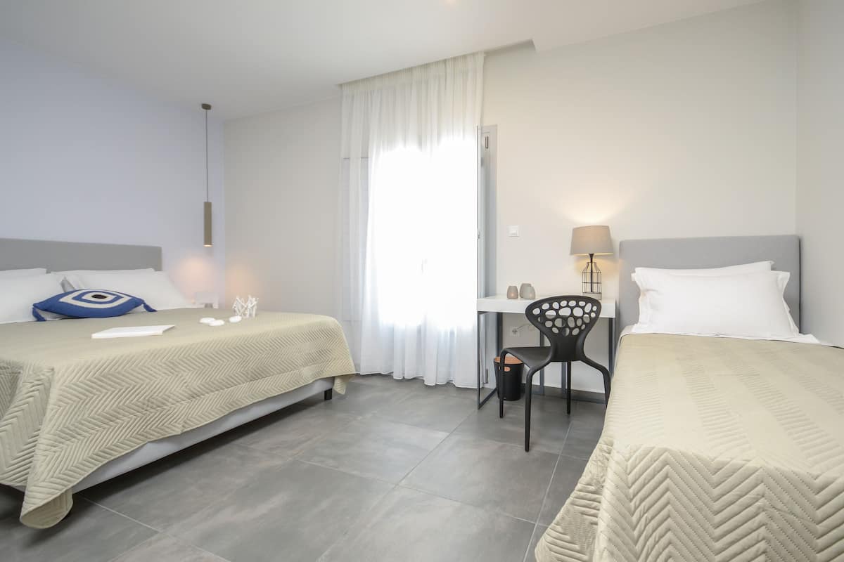 Superior Triple Room with Garden View | Seprai premium, brankas, meja kerja, dan tirai kedap cahaya