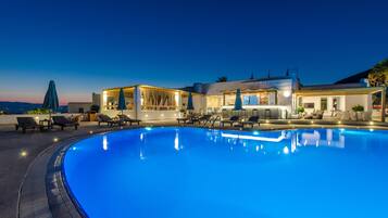 Una piscina al aire libre de temporada, sombrillas