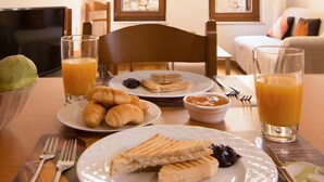 A breakfast table with croissants, a slice of cake, and juice glasses. - Daliani Studios Chania (Chania)