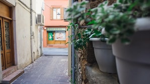 A narrow cobblestone street with a pharmacy on the right and a building with a wooden door on the left. - Daliani Studios Chania (Chania)