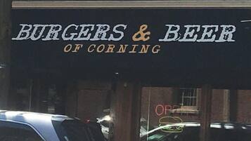 Un escaparate con un letrero que dice 'BURGERS & BEER OF CORNING'.