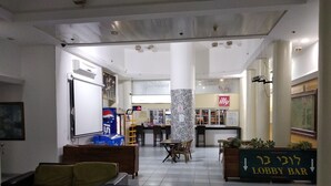 Un espace d’accueil avec des sièges, un bar et un tableau blanc.