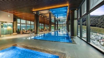 Una piscina techada, sillones reclinables de piscina