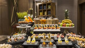Un bufé con diversas opciones de comida y una exhibición de frutas.