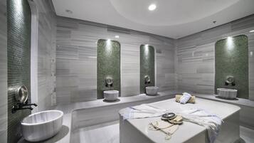 Un baño moderno con una bañera independiente, dos lavamanos en la pared y un espejo grande.