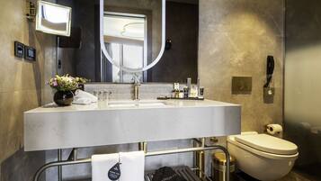 A modern bathroom with a large mirror, a sink, and a toilet.