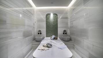 A modern bathroom with a central bench, two sinks, and a decorative mosaic wall.