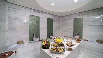 A luxurious bathroom with a marble vanity, a bathtub, and a large mirror.