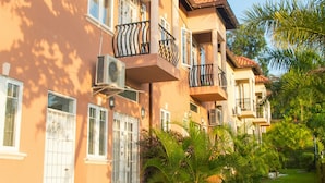 A row of multi-story residential buildings with balconies, air conditioning units, and a well-maintained garden area. - 3 bdrm Town House at Runaway Bay (Runaway Bay)
