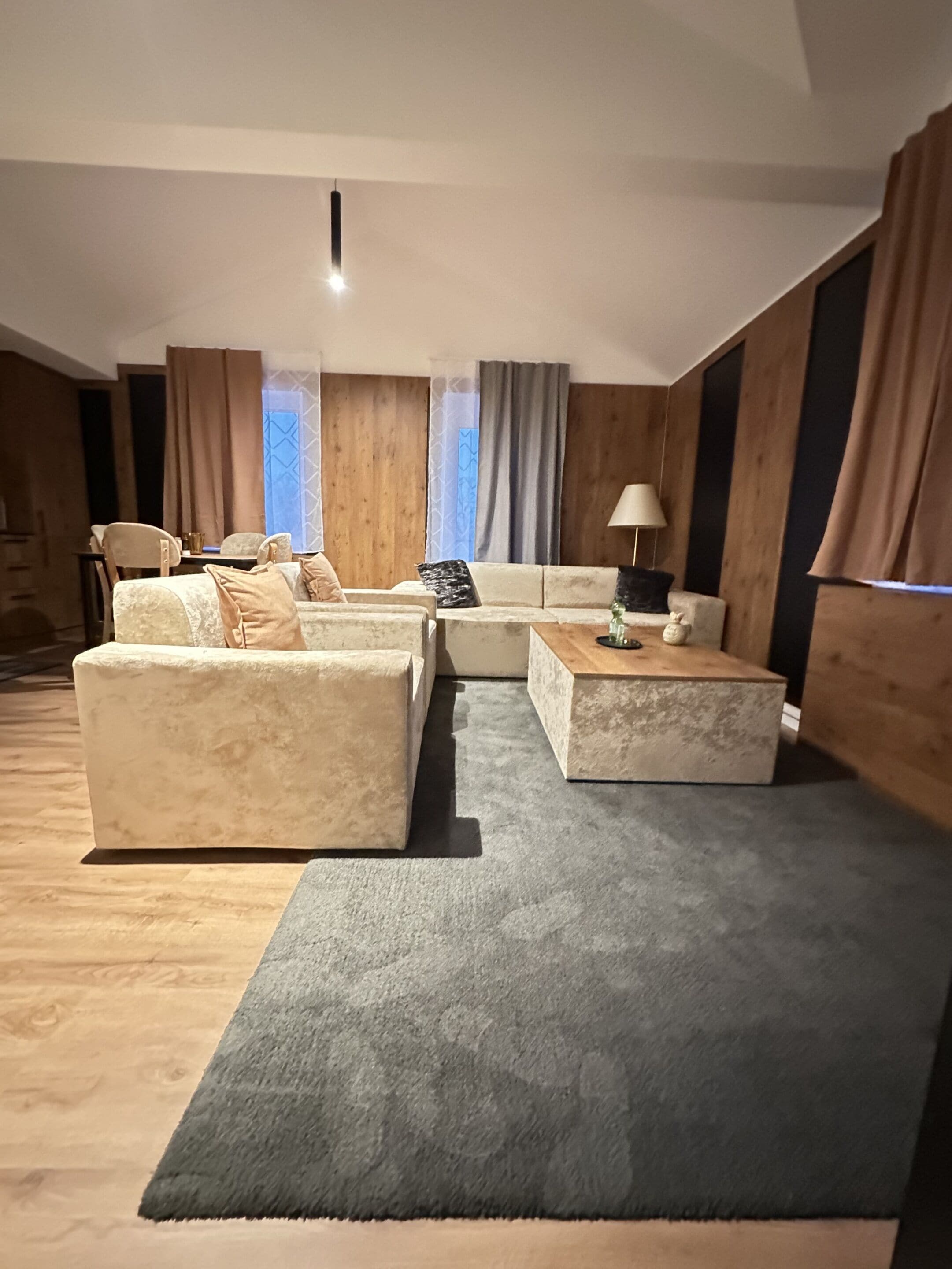 Una sala de estar con un sofá, una mesa de centro y una lámpara.