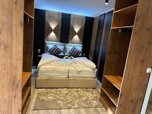 A bedroom with a bed, headboard, pillows, and a rug. - Apartmenthaus Zeuthen (Zeuthen)