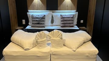 A bedroom with a bed, two nightstands, a wooden headboard, and a patterned rug.