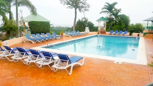 Piscina amb gandules blaves i senyal de vigilant de servei.