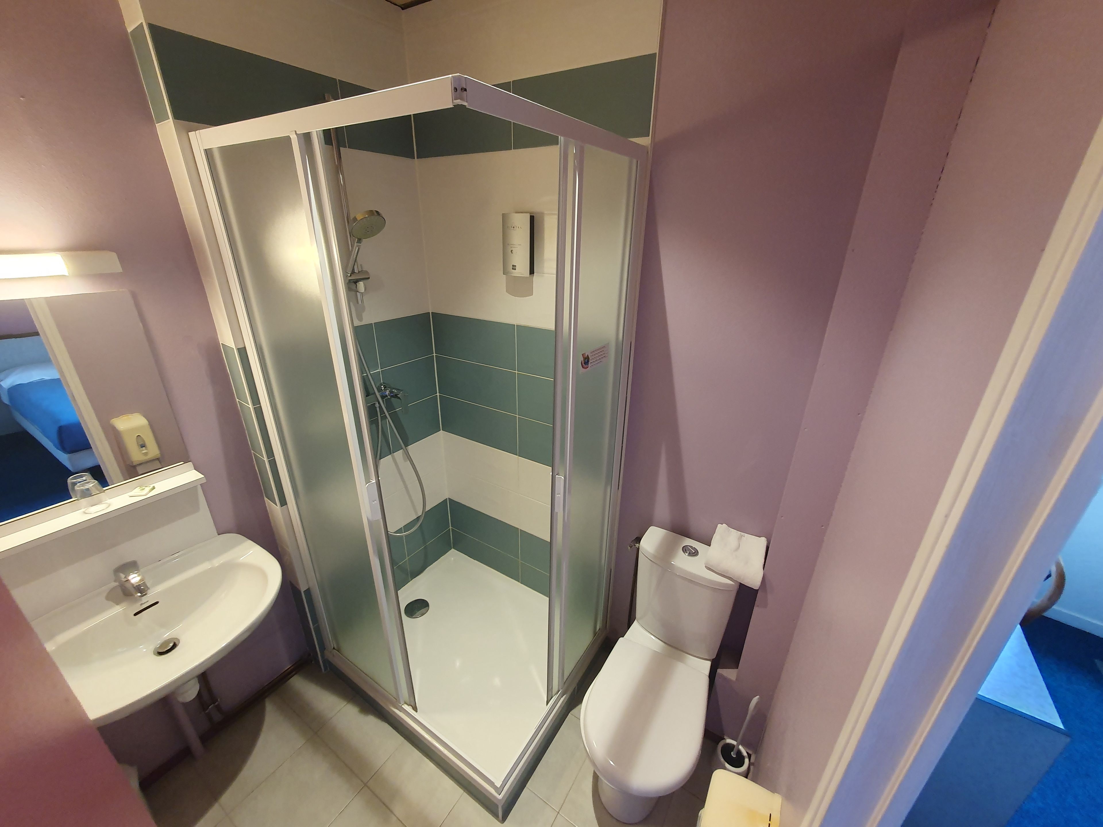 Une salle de bain avec une douche à parois de verre, un lavabo et des toilettes.