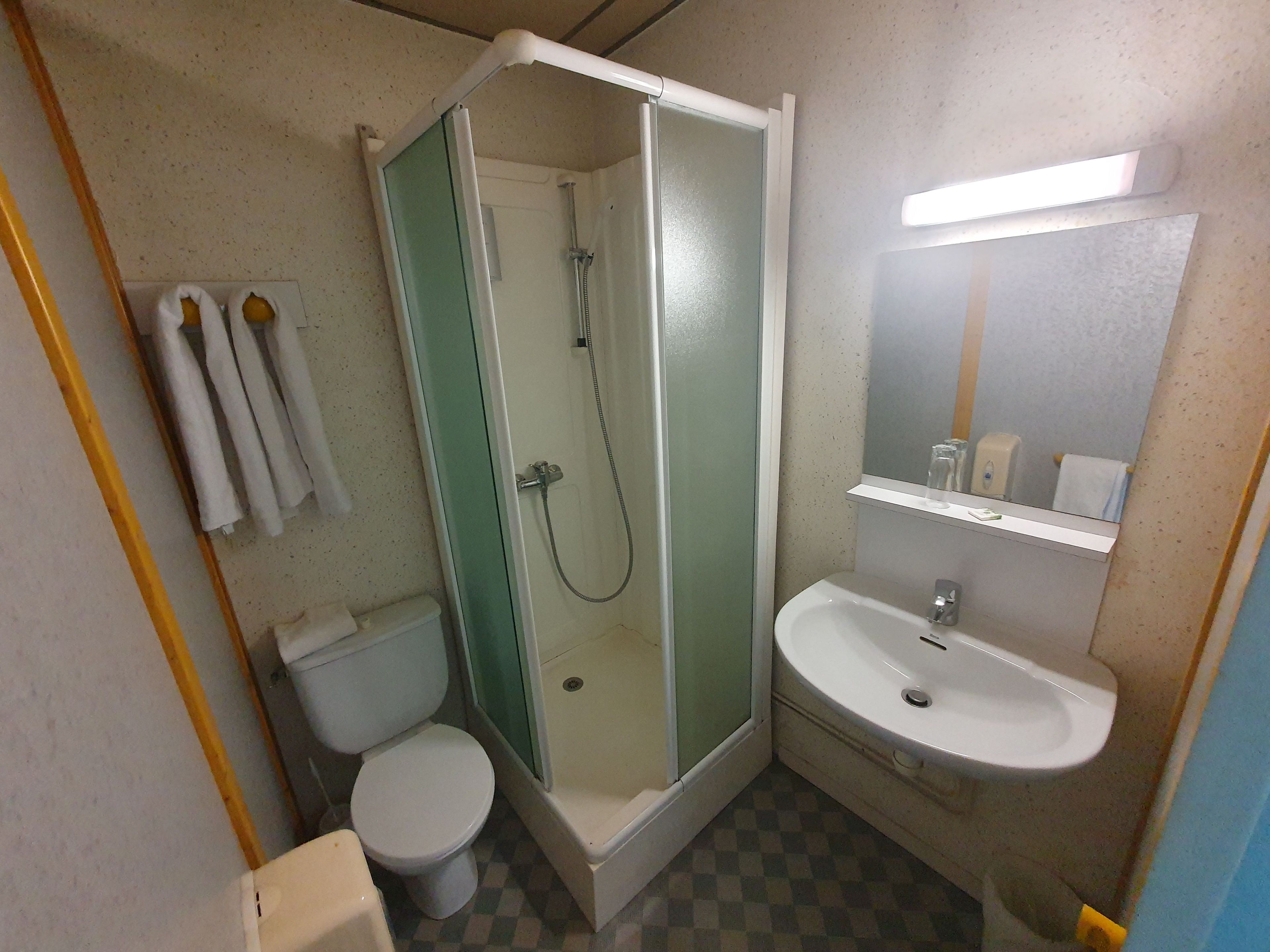 A bathroom with a shower, toilet, and sink.