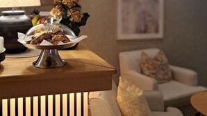 Una mesa de comedor con un plato cubierto, una lámpara y un florero con flores.