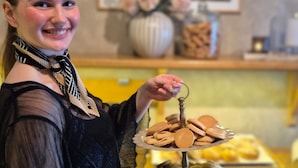 Una persona sosteniendo una bandeja con galletas y pasteles.