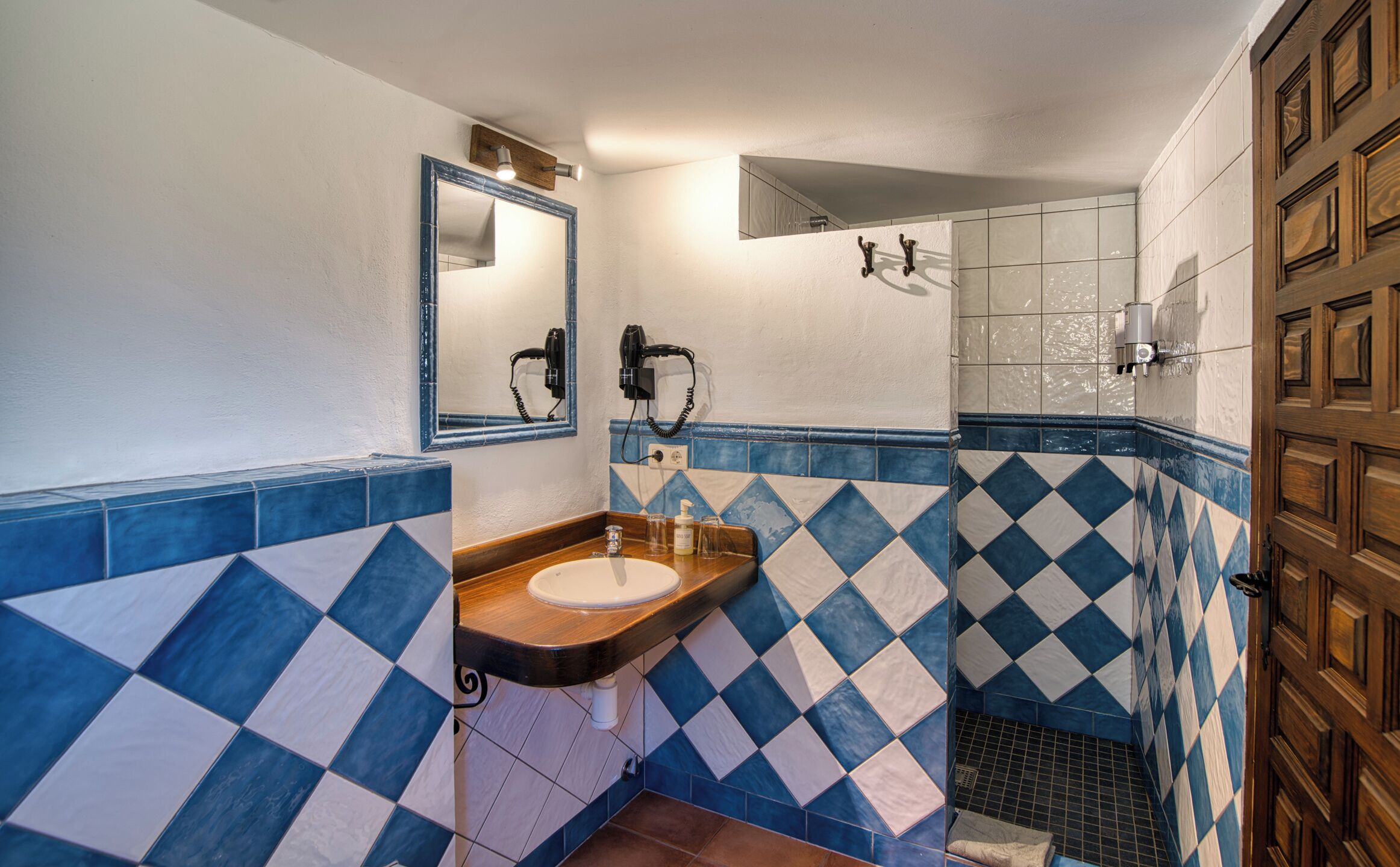 Un baño con lavabo, espejo y ducha.