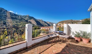 A terrace with a table and chairs, overlooking a mountainous landscape. - Casa Rural Arroyo de la Greda (Guejar Sierra)