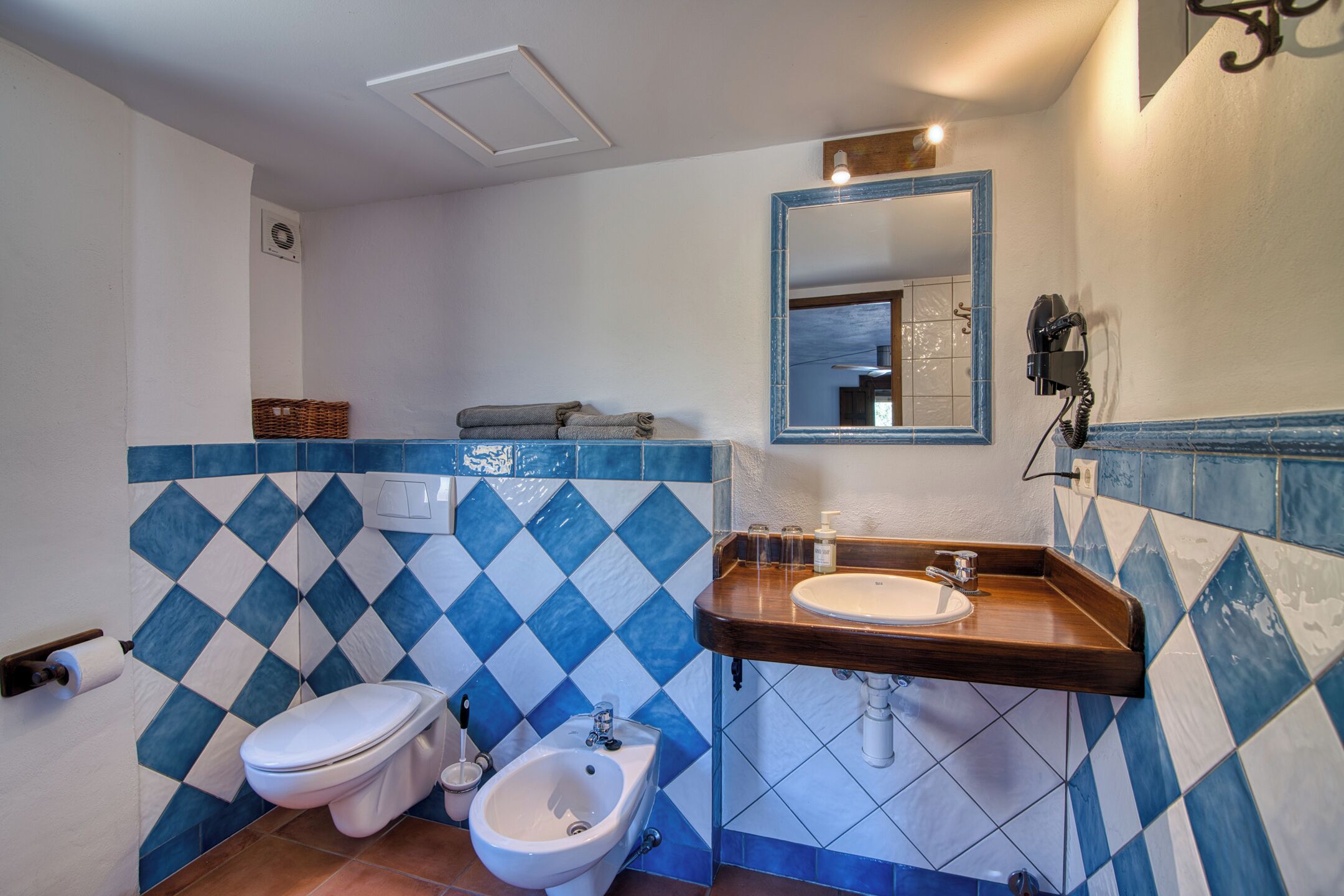 Een badkamer met toilet, bidet en wastafel.