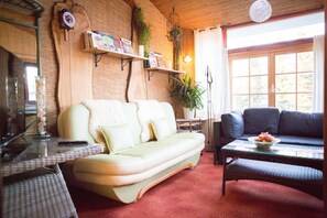 Una sala de estar acogedora con un sofá, una mesita de centro con fruta y una estantería.