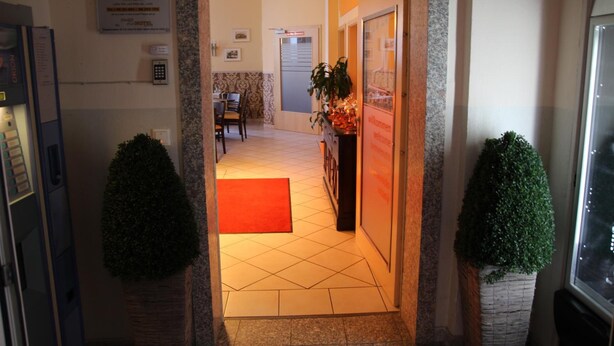 Un hall d’hôtel comprenant un comptoir d’accueil, un espace repas et une enseigne indiquant le nom de l’hôtel.