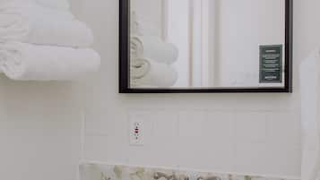 Een bad/douchecombinatie, designer toiletartikelen, een haardroger