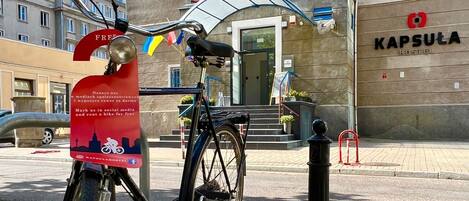 Una bicicleta estacionada frente a un edificio con un letrero que dice "KAPSULA HOSTEL".