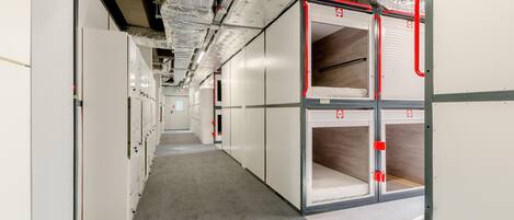A corridor with storage units and a fire safety system.