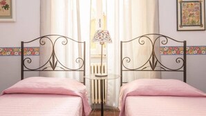 A room with two beds, a radiator, and a lamp between them. - Navona Charming Terrace Apartment (Rome)