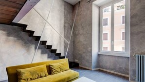 En modern inredning med en soffa, en trappa och ett fönster.