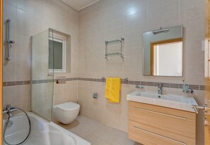 Un baño moderno con bañera, inodoro y lavamanos.