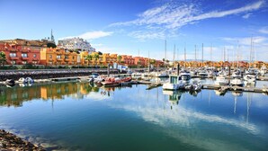 A marina with boats docked, a clear sky, and colorful buildings in the background. - Binge Green Apartment, Wifi, AC (Faro)