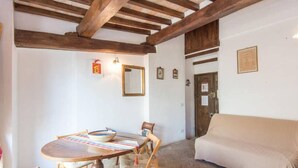 Un comedor con una mesa redonda, sillas y techo de madera.
