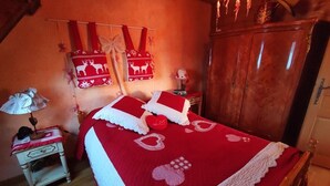 Une chambre confortable avec un lit en bois, une table de chevet avec une lampe et une armoire.