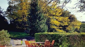 A patio area with outdoor furniture and a gravel ground. - Charming cottage in the country of Futuroscope (Persac)