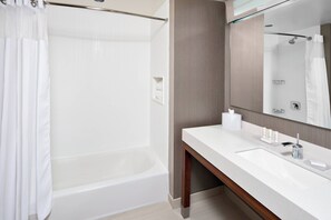 Ein modernes Badezimmer mit einer Badewanne, einem Waschtisch und einem großen Spiegel.
