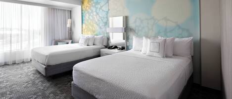 Habitación de hotel con dos camas, un ventanal con cortinas translúcidas, un mural abstracto moderno y alfombra gris.