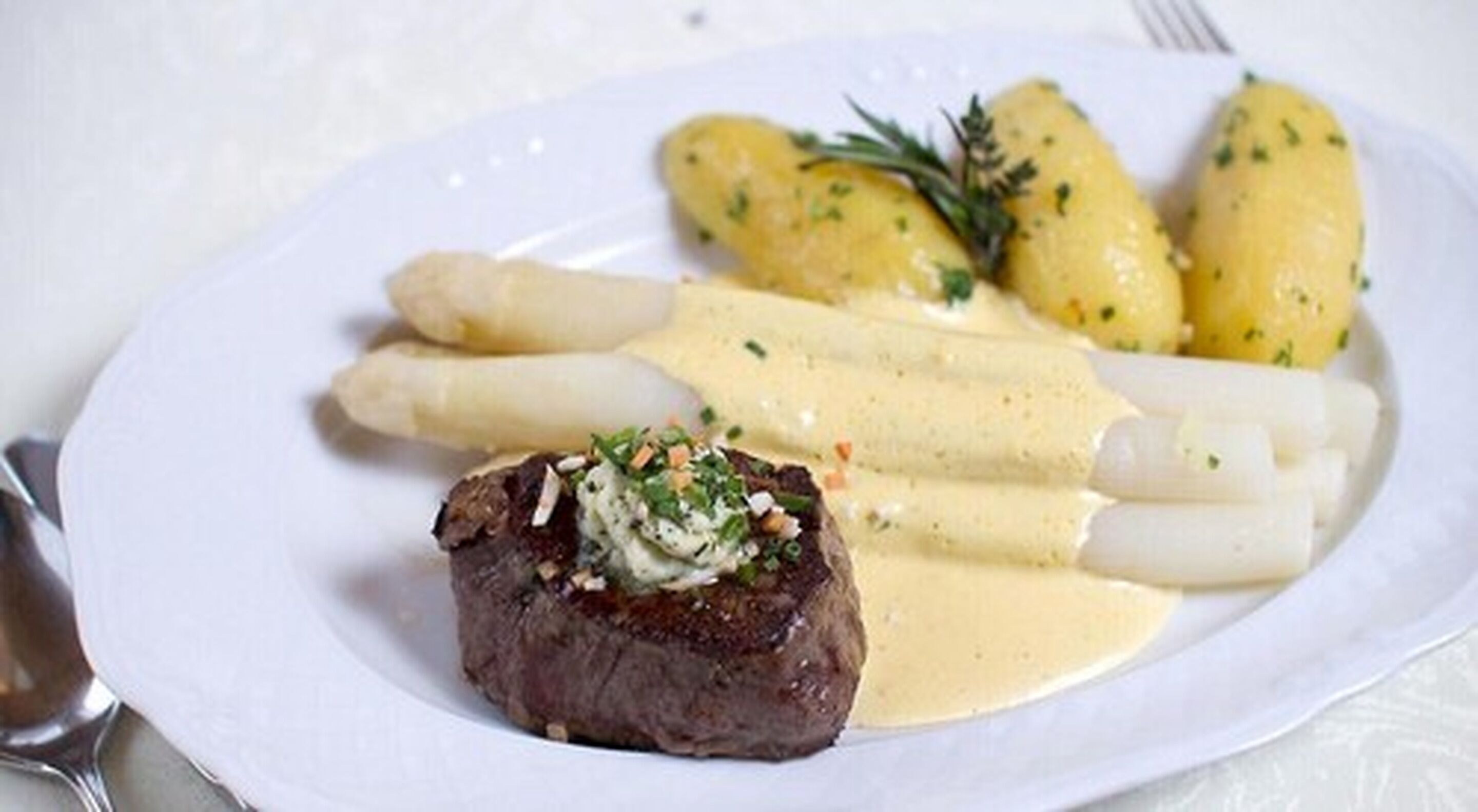 A plate with steak, asparagus, and potatoes.