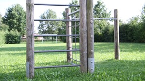 Una verja de metal con postes de madera en un área cubierta de césped.